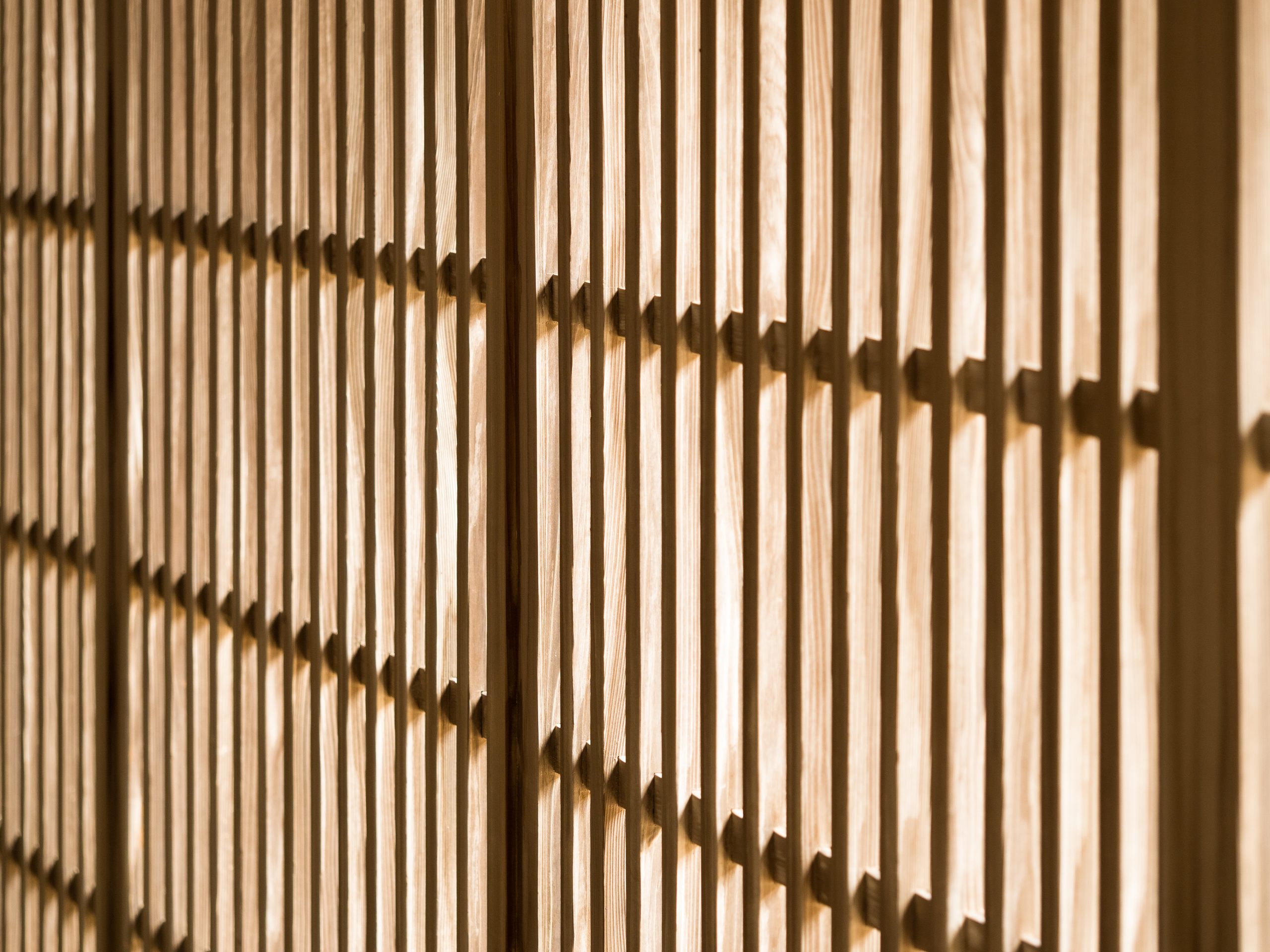 Warm light falling across a wooden lattice screen