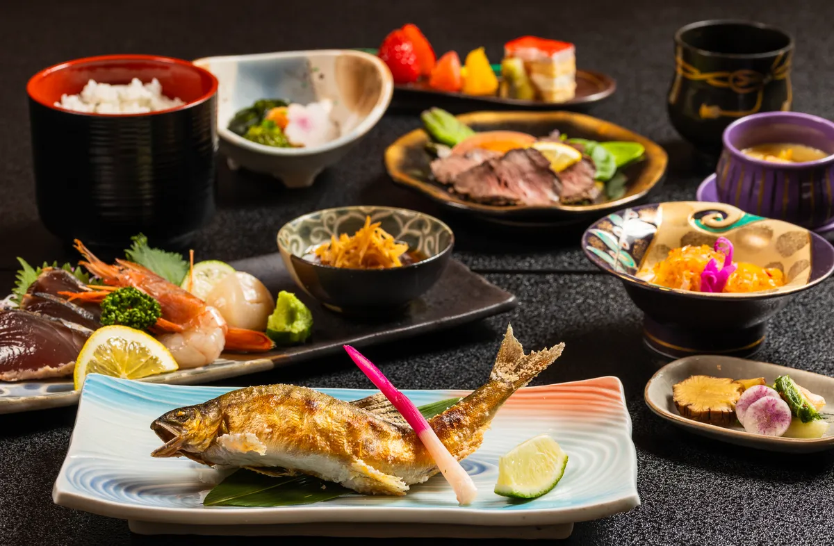A kaiseki spread of grilled ayu, sashimi, rice in a lacquer bowl and small seasonal dishes
