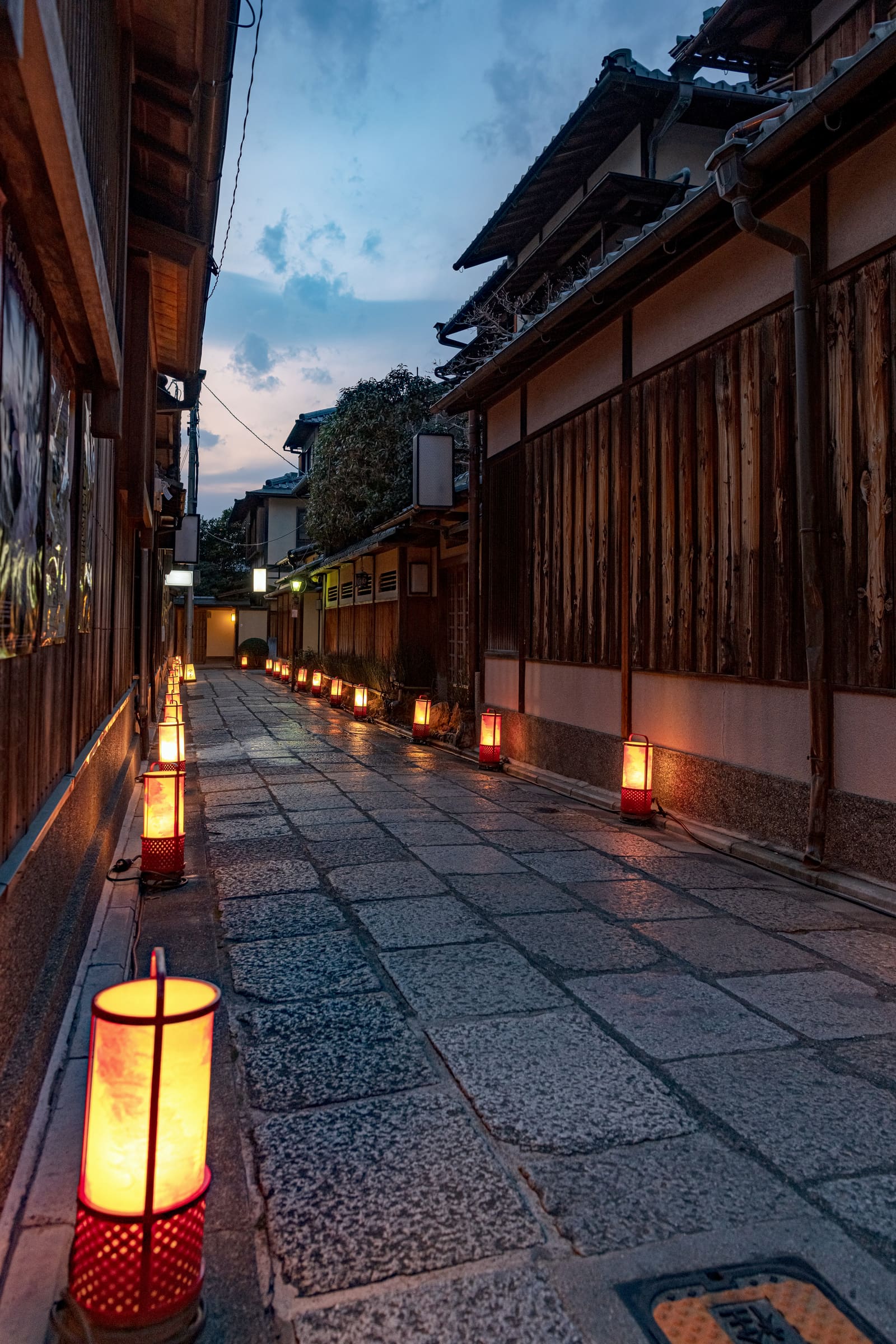 A lantern-lined stone lane in Kyoto at dusk