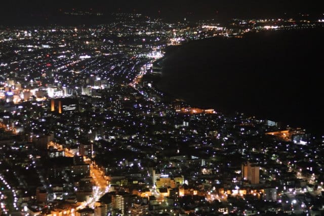 The lights of Hakodate spread along the curve of the bay, seen at night from Mount Hakodate