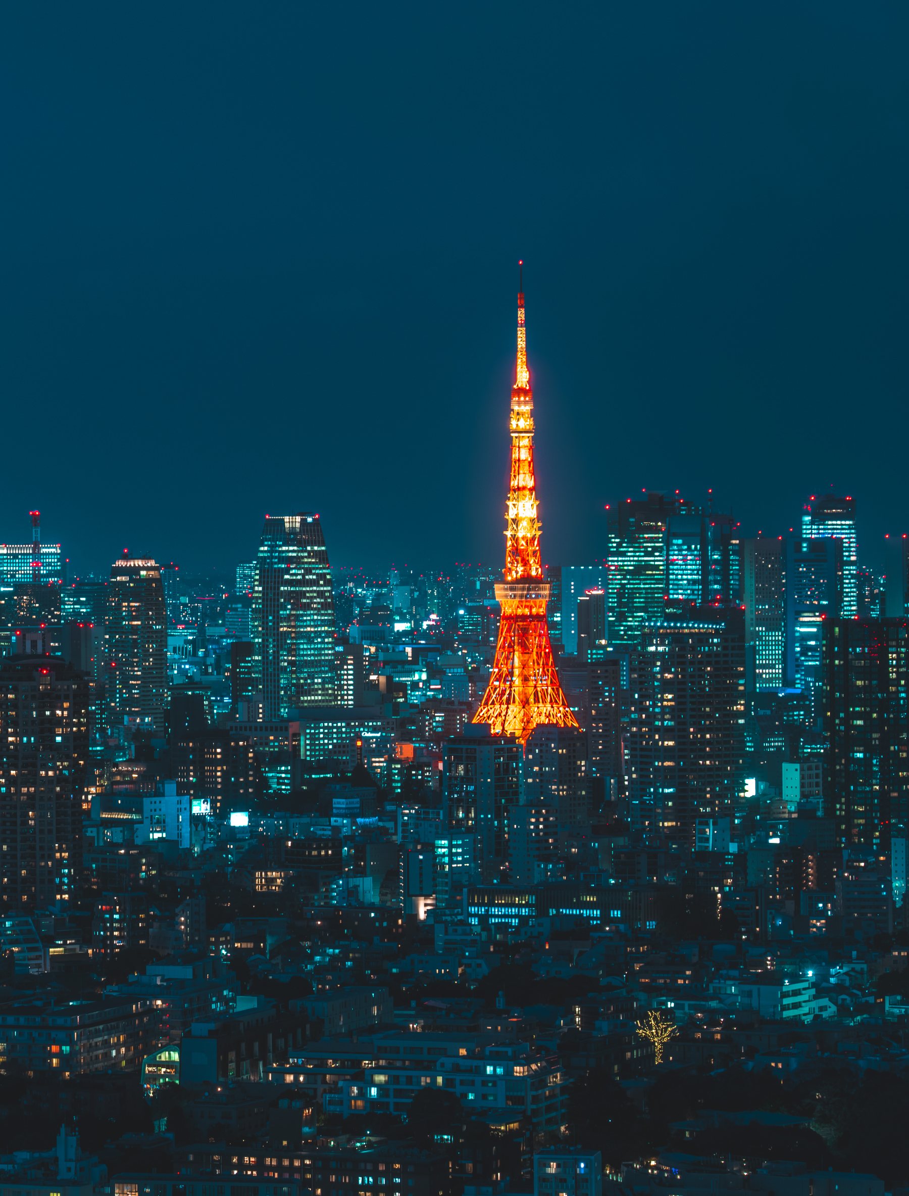 Tokyo at night from above, Tokyo Tower lit orange among the towers of the city