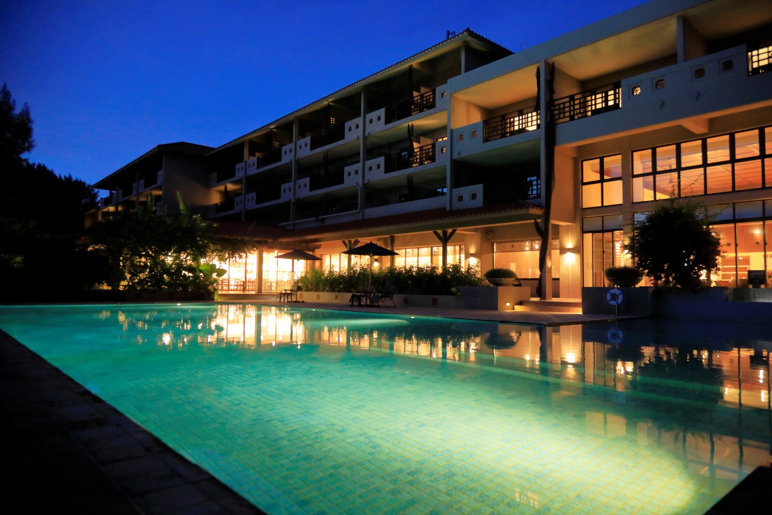 The hotel and its pool lit at dusk