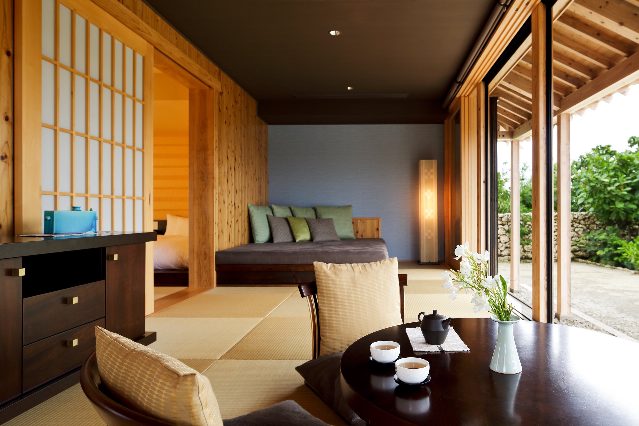 A room with a tatami sitting area, a low table set for tea and a timber veranda