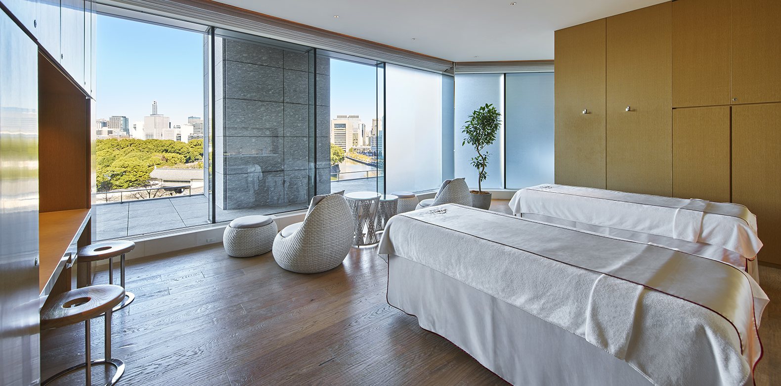 A treatment room in the spa, two beds before a window onto the trees of the palace grounds