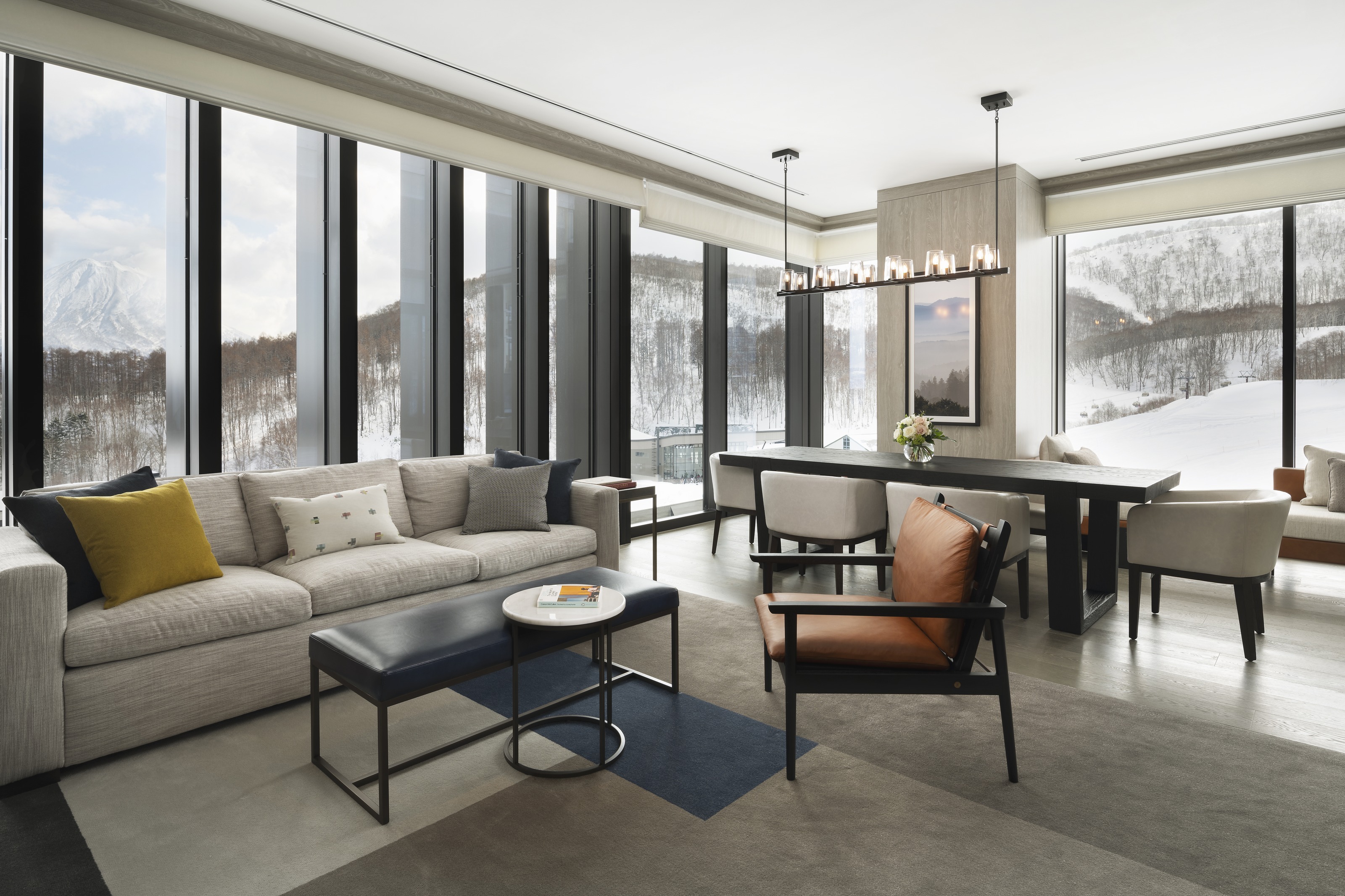 A suite living room with deep sofas and tall windows onto the snowy slopes