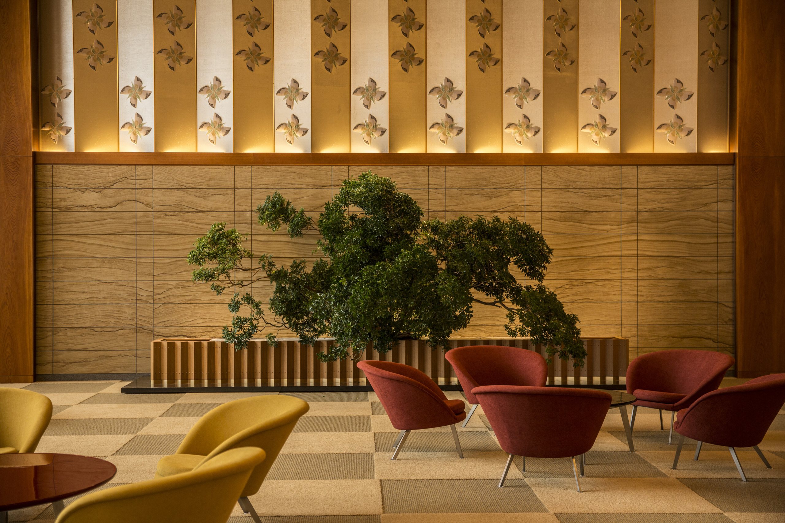 The long lobby of The Okura Tokyo, low chairs beneath hanging lanterns and a lattice of paper screens