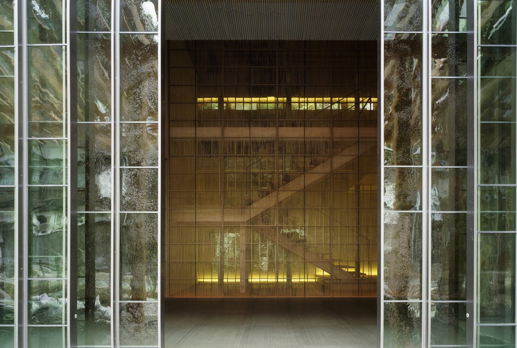 The interior of Fujiya, a tall space of bamboo screens and warm light