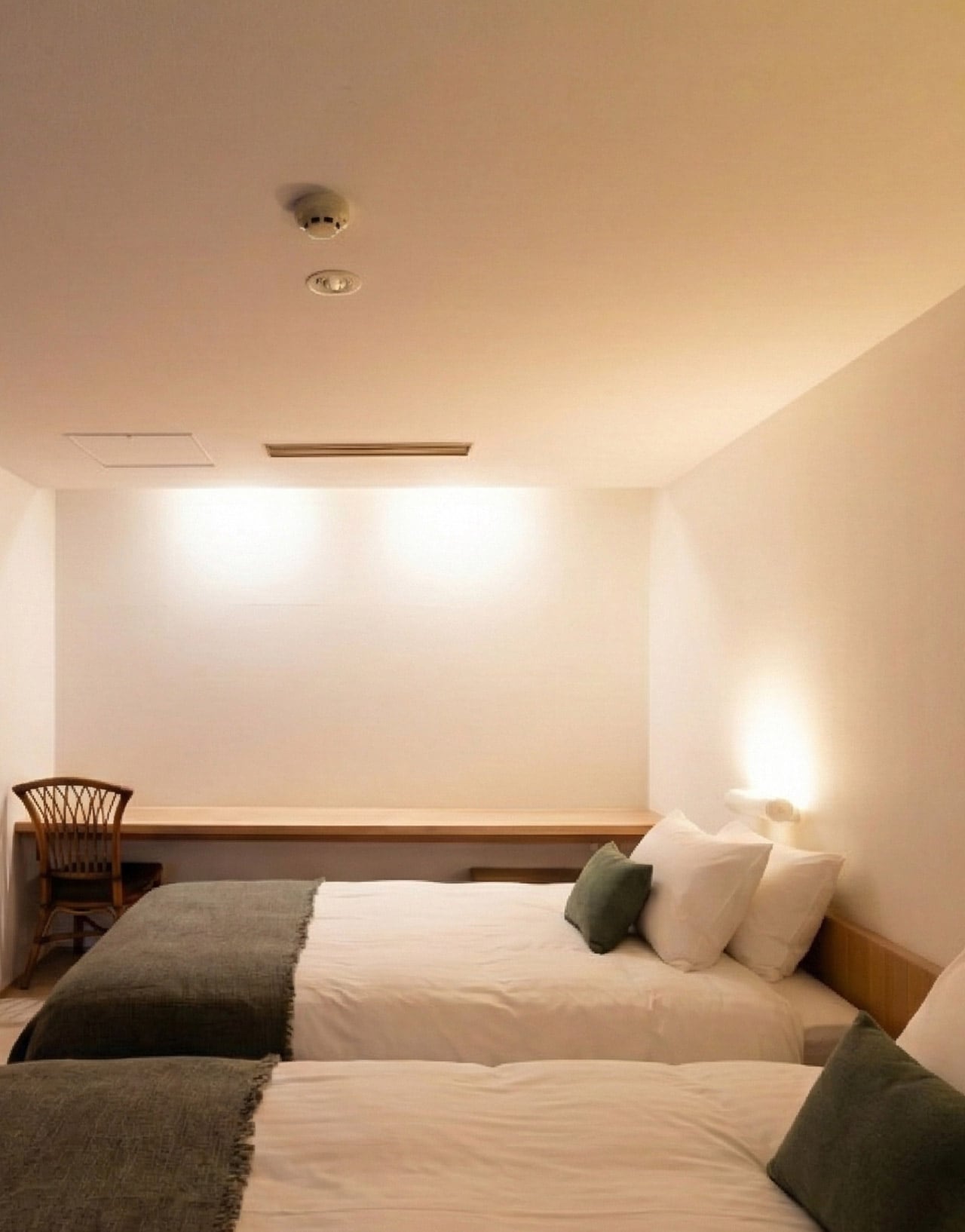 A suite at Kuramure in dark timber and stone, tall windows onto the trees