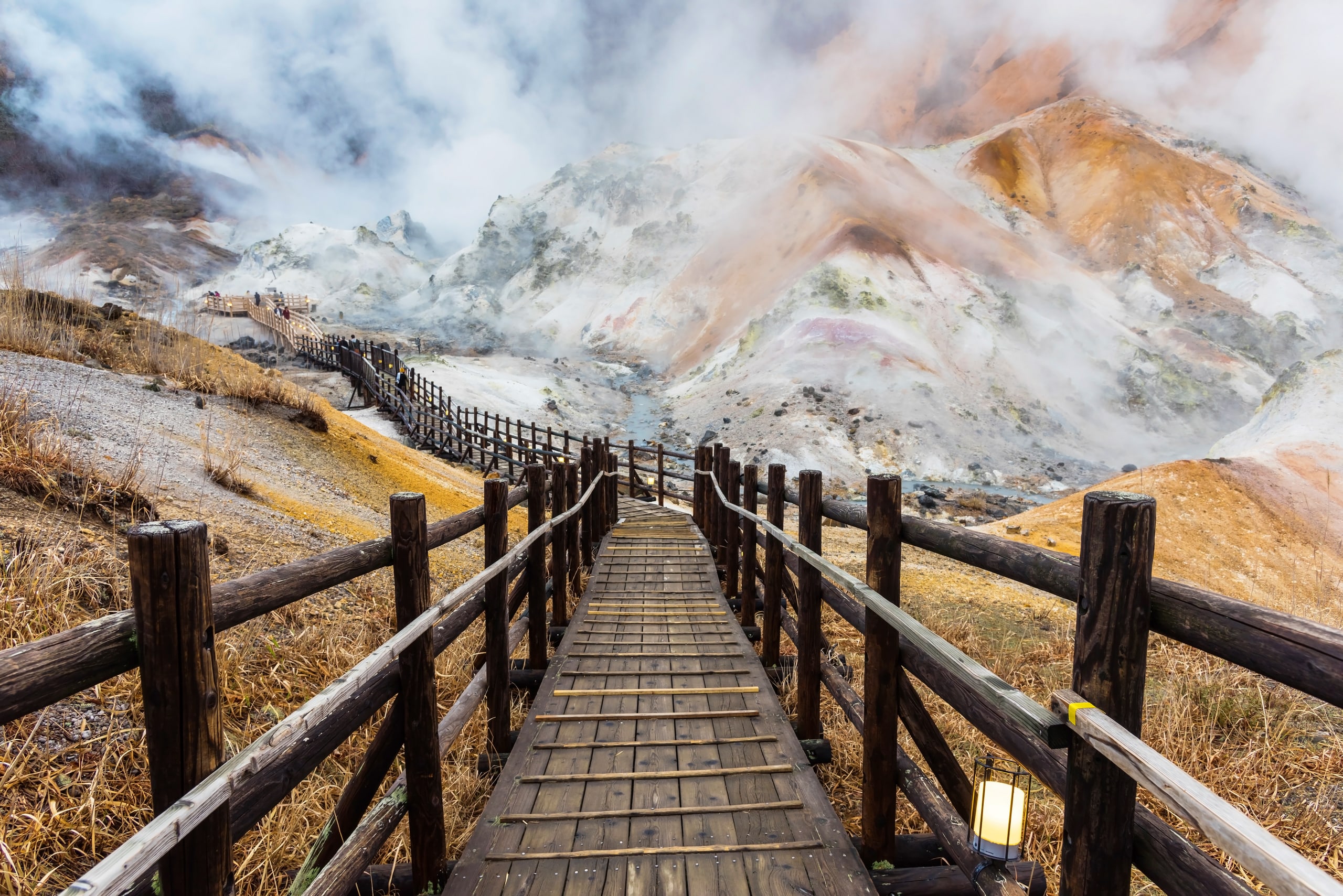 A wooden boardwalk leading down into the steaming valley of Jigokudani, Noboribetsu