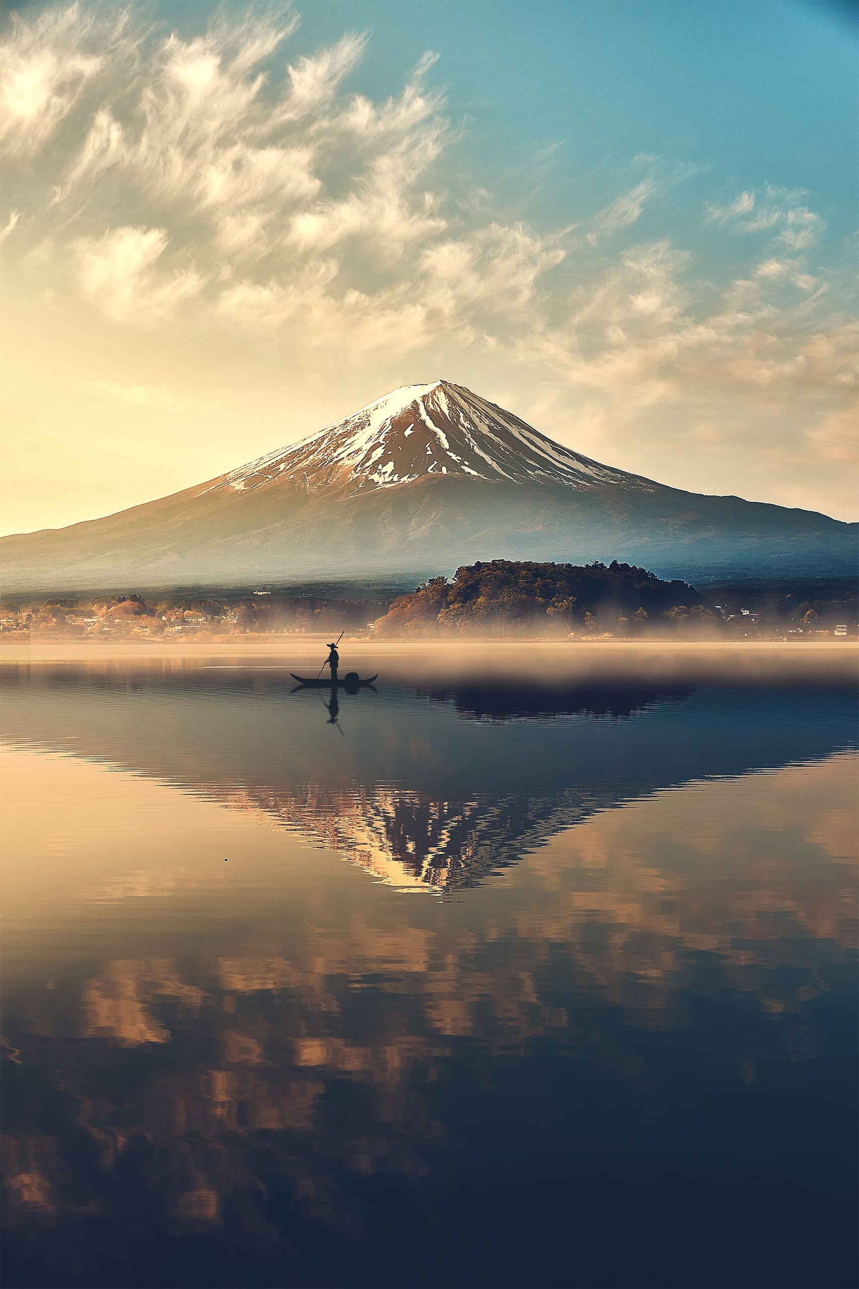 Mount Fuji under a warm sky, mirrored whole in the still lake below it, a lone fisherman on the far water
