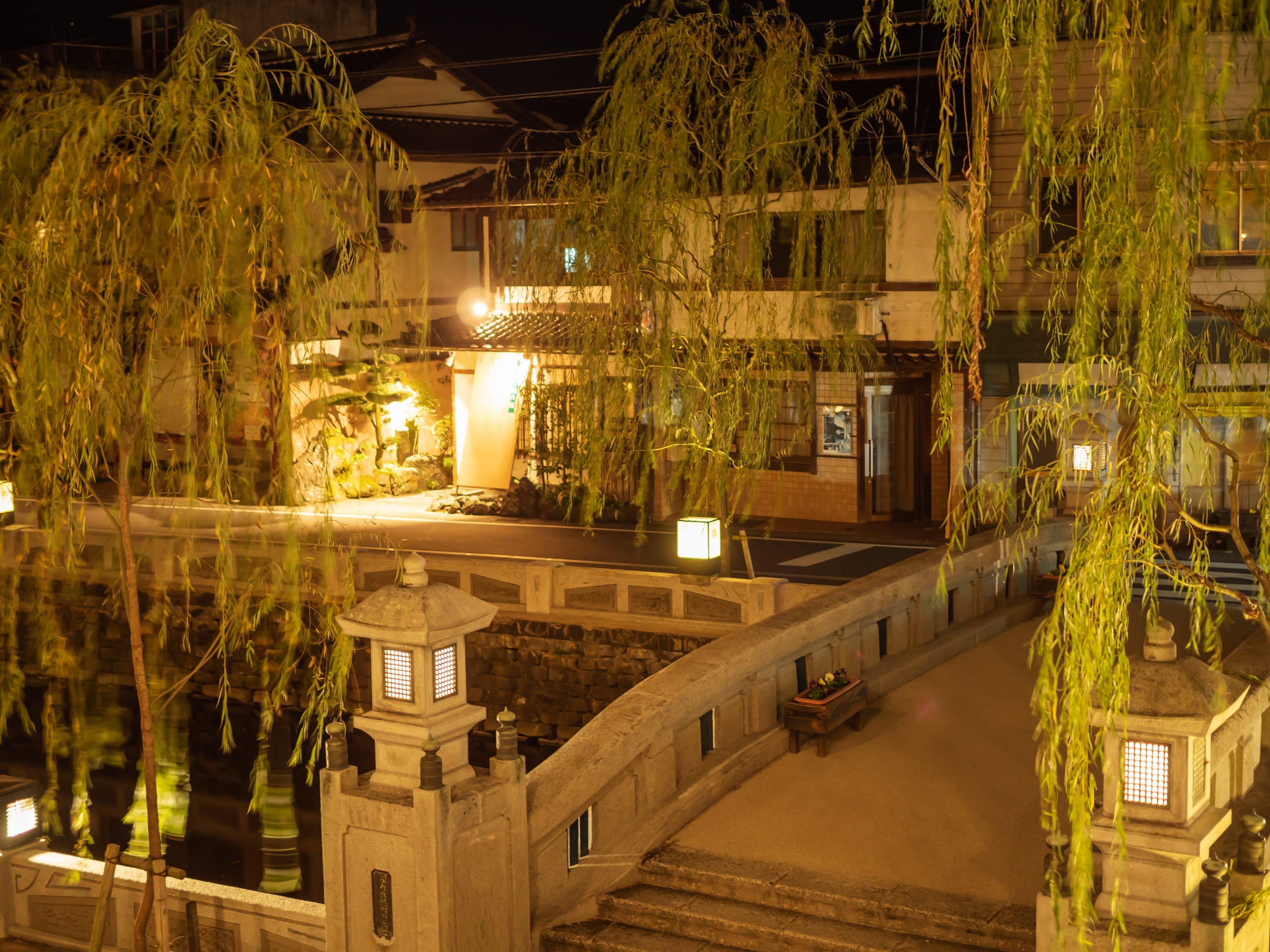 The stone bridges and willows of the Kinosaki canal, after dark