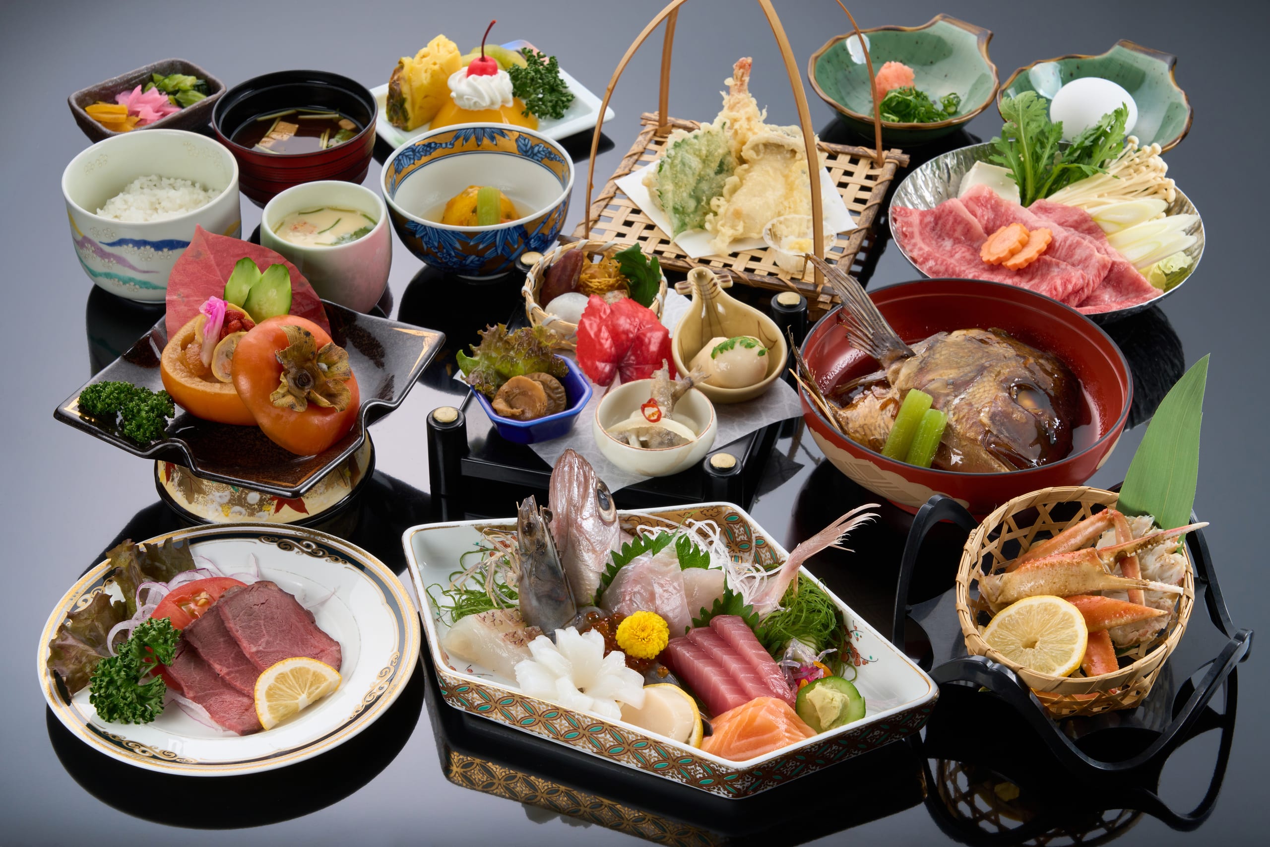 A kaiseki dinner laid on black lacquer trays: sashimi, beef and the small dishes of the season