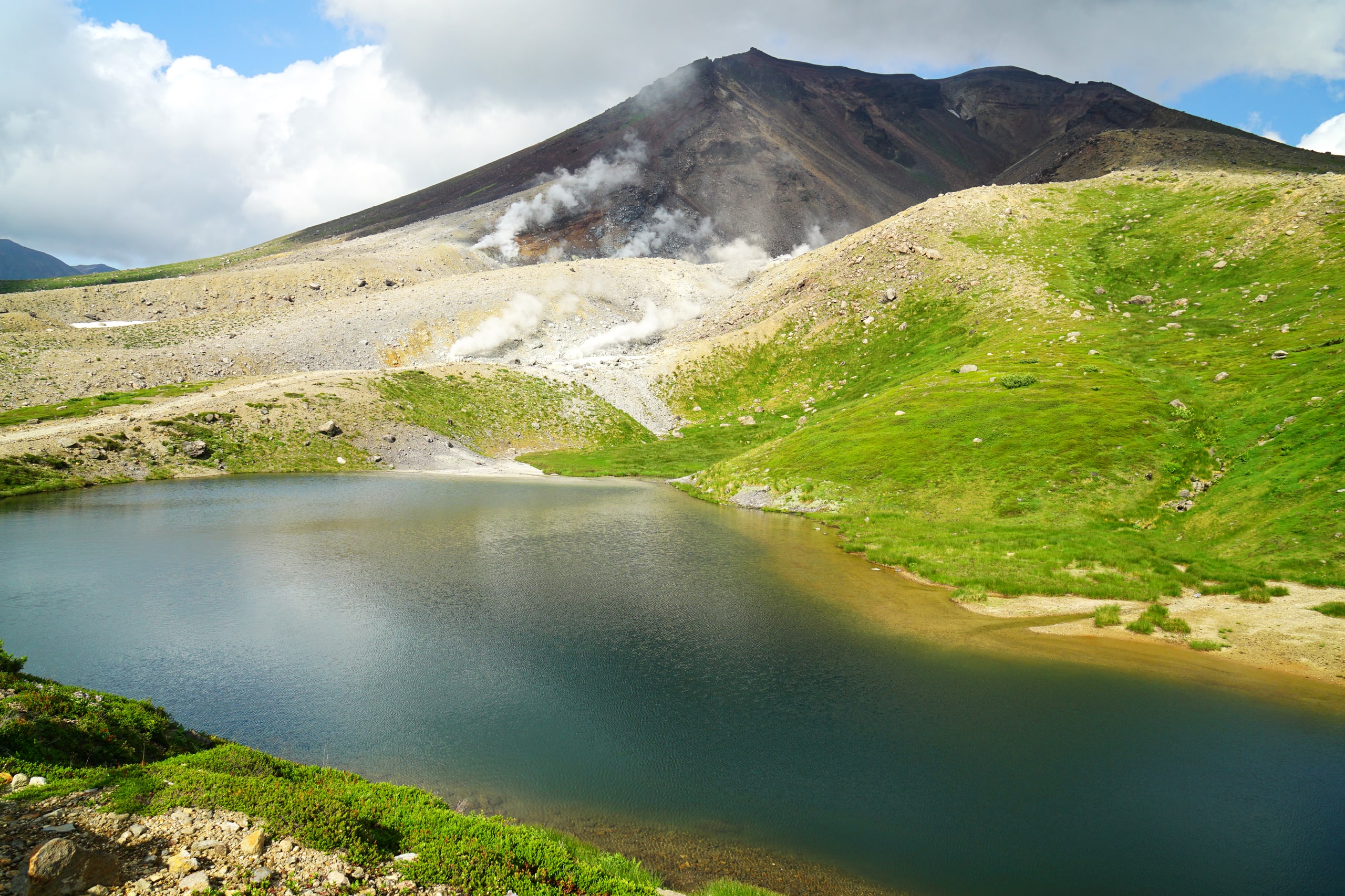 Asahidake steaming above Sugatami Pond, the green slopes of the Daisetsuzan high country in July